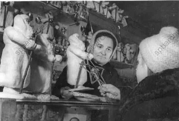 1942. Продавщица отдела игрушек одного из магазинов Ленпромторга К.И. Цыганенко показывает юной покупательнице елочные украшения