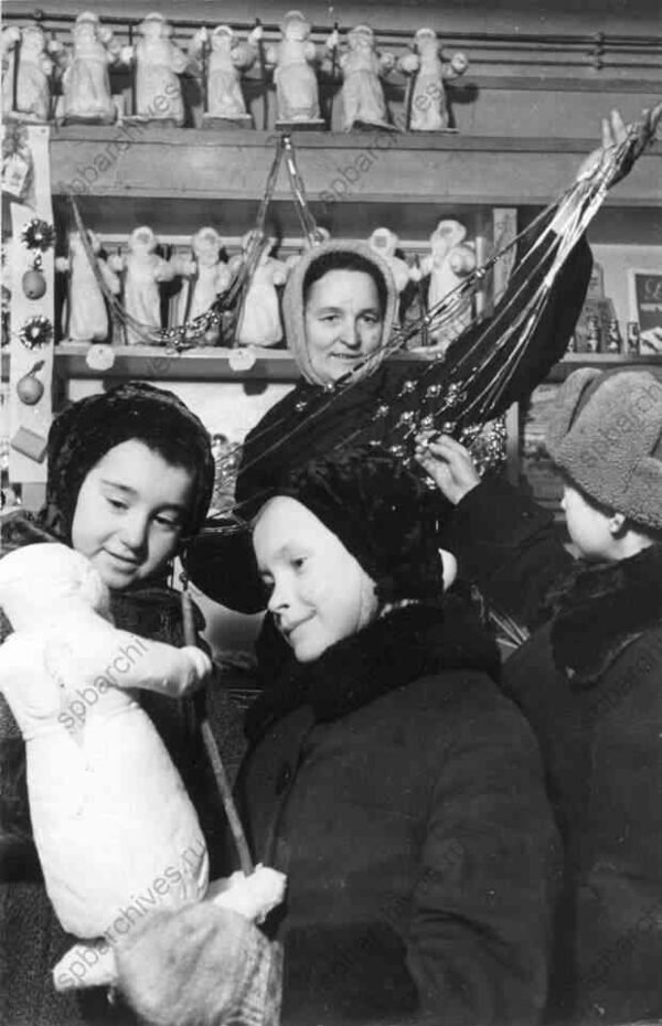 1942. Юные покупатели в одном из магазинов Ленпромторга выбирают Деда Мороза